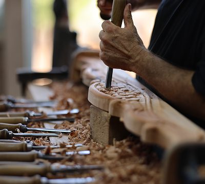 Hands shaping wood sculpture