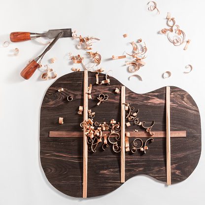 Guitar back with wood curls and tools.